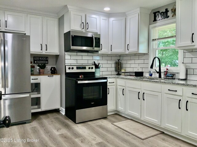 444 Lagrange Rd, New Castle, KY 40050 - kitchen featuring stainless steel appliances, white cabinetry, light wood-style flooring, decorative backsplash, and recessed lighting
