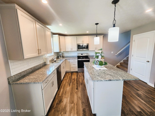 12630 Orell Station Pl, Louisville, KY 40272 - kitchen featuring appliances with stainless steel finishes, recessed lighting, dark wood-type flooring, a center island, and light stone countertops
