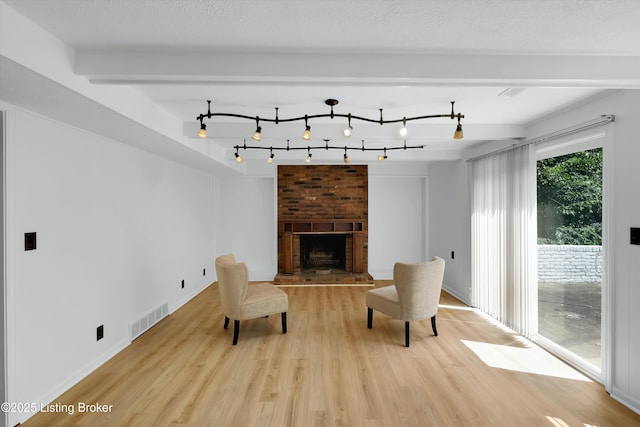 3407 Hillsboro Rd, Louisville, KY 40207 - unfurnished room featuring light wood finished floors, a fireplace, rail lighting, and beamed ceiling
