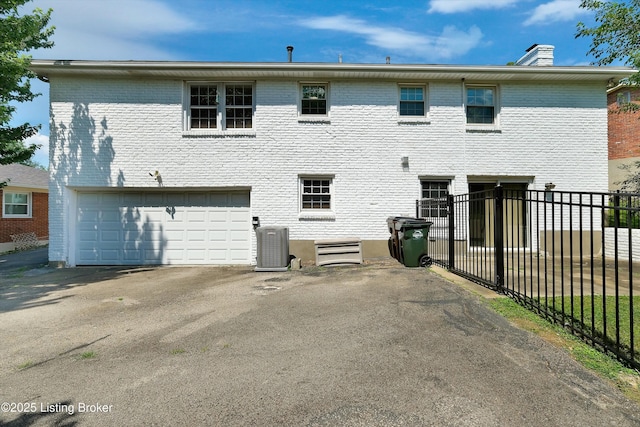 3407 Hillsboro Rd, Louisville, KY 40207 - rear view of property featuring a garage, asphalt driveway, a chimney, and brick siding