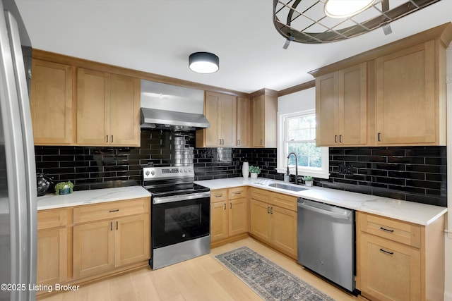 3407 Hillsboro Rd, Louisville, KY 40207 - kitchen featuring appliances with stainless steel finishes, wall chimney range hood, light brown cabinets, backsplash, and light wood finished floors
