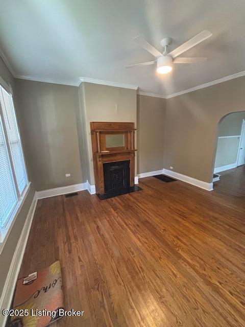 1842 Deer Park Ave, Louisville, KY 40205 - unfurnished living room featuring a fireplace, wood finished floors, ceiling fan, arched walkways, and crown molding