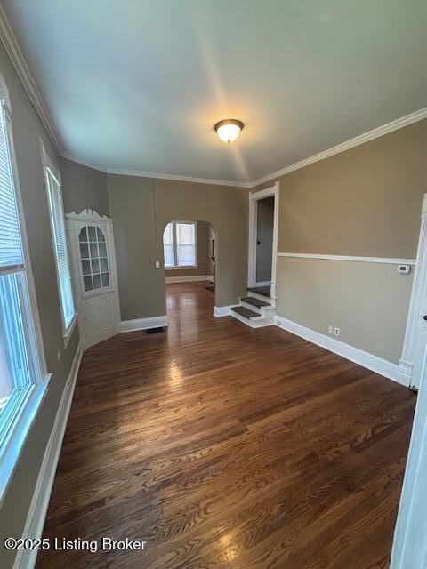 1842 Deer Park Ave, Louisville, KY 40205 - empty room featuring arched walkways, dark wood-type flooring, and crown molding
