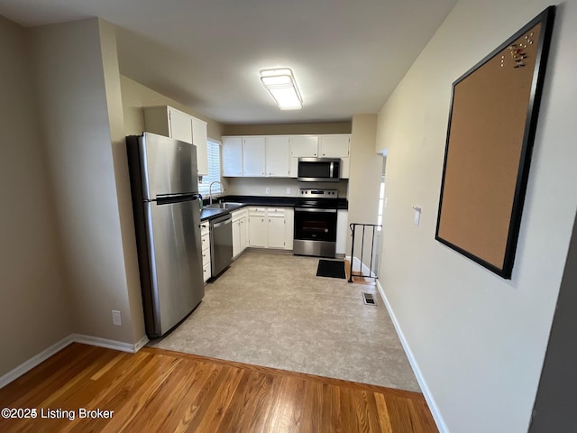 3510 Ethelwood Dr, Jeffersontown, KY 40299 - kitchen with appliances with stainless steel finishes, dark countertops, light wood-type flooring, and white cabinetry