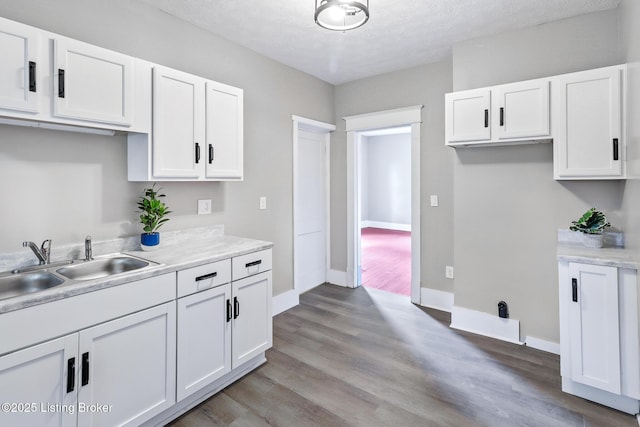 2522 Wilson Ave, Louisville, KY 40210 - kitchen with white cabinets, light countertops, light wood finished floors, and a textured ceiling
