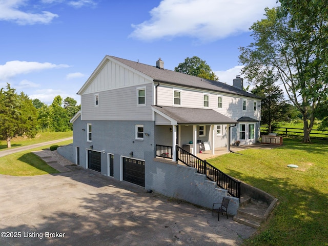 10020 Oak Grove Rd, Louisville, KY 40291 - view of front of house featuring board and batten siding, an attached garage, a chimney, and asphalt driveway