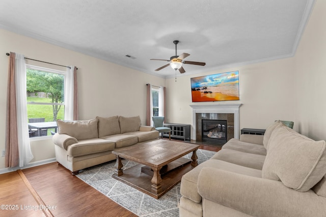 10008 Hornbeam Blvd, Louisville, KY 40228 - living area featuring a tile fireplace, a ceiling fan, crown molding, and wood finished floors