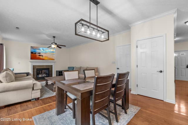 10008 Hornbeam Blvd, Louisville, KY 40228 - dining space featuring ornamental molding, wood finished floors, a ceiling fan, and a glass covered fireplace
