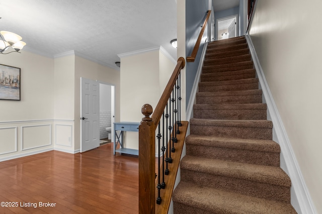 10008 Hornbeam Blvd, Louisville, KY 40228 - stairs with hardwood / wood-style floors, a chandelier, ornamental molding, a wainscoted wall, and a textured ceiling