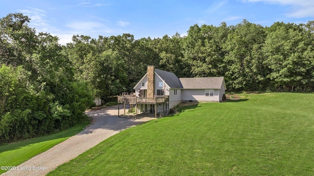 4333 Wax Rd, Clarkson, KY 42726 - view of property exterior featuring asphalt driveway, a deck, a lawn, a chimney, and a wooded view