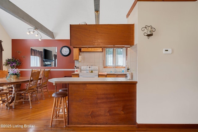 4333 Wax Rd, Clarkson, KY 42726 - kitchen with white range with electric stovetop, tile countertops, light wood finished floors, backsplash, and a peninsula