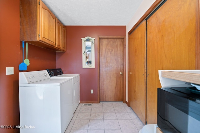 4333 Wax Rd, Clarkson, KY 42726 - washroom featuring washer and clothes dryer, cabinet space, light tile patterned flooring, and a textured ceiling