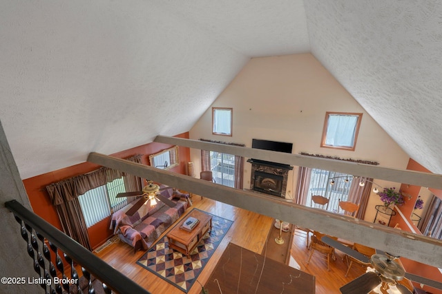4333 Wax Rd, Clarkson, KY 42726 - living area featuring a textured ceiling, wood finished floors, a ceiling fan, a premium fireplace, and high vaulted ceiling