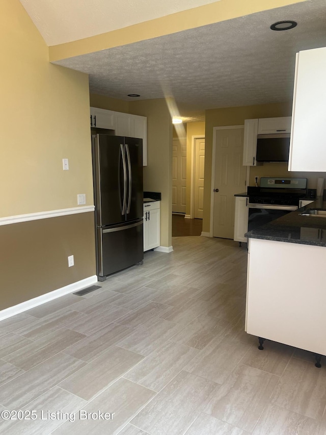 9403 Alex Ct, Louisville, KY 40299 - kitchen featuring stainless steel appliances, white cabinetry, dark countertops, and a textured ceiling