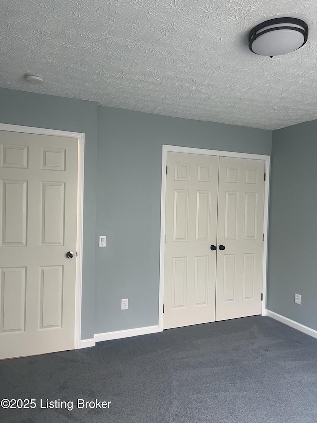 9403 Alex Ct, Louisville, KY 40299 - unfurnished bedroom featuring a closet, dark carpet, and a textured ceiling