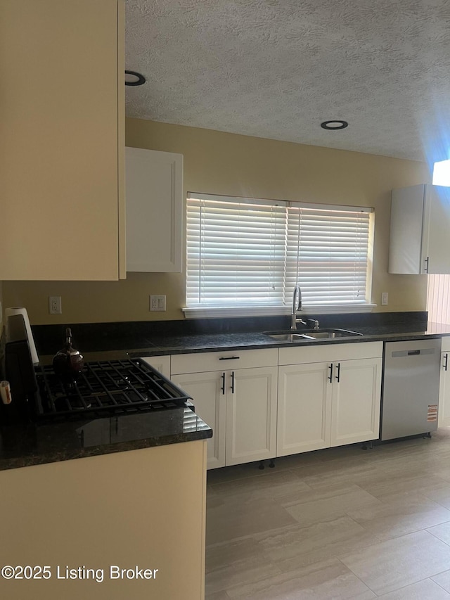 9403 Alex Ct, Louisville, KY 40299 - kitchen featuring stainless steel dishwasher, dark countertops, a textured ceiling, healthy amount of natural light, and white cabinetry