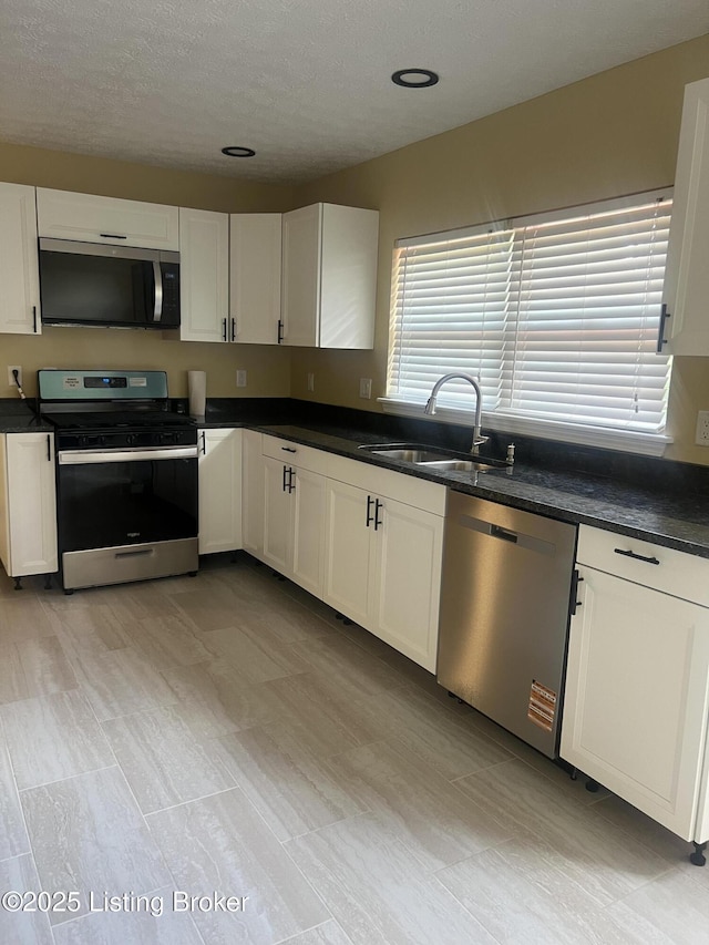 9403 Alex Ct, Louisville, KY 40299 - kitchen with stainless steel appliances, dark countertops, white cabinets, and a textured ceiling