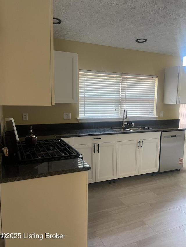 9403 Alex Ct, Louisville, KY 40299 - kitchen with stainless steel dishwasher, healthy amount of natural light, a textured ceiling, and white cabinetry