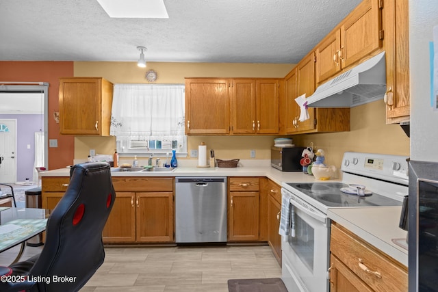 1291 Lipps Ln, Louisville, KY 40219 - kitchen featuring appliances with stainless steel finishes, under cabinet range hood, light countertops, a skylight, and brown cabinets