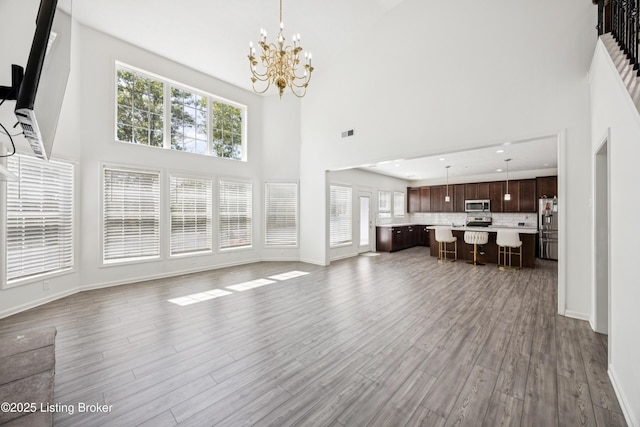 14433 Halden Ridge Way, Louisville, KY 40245 - unfurnished living room featuring a high ceiling, wood finished floors, and a chandelier