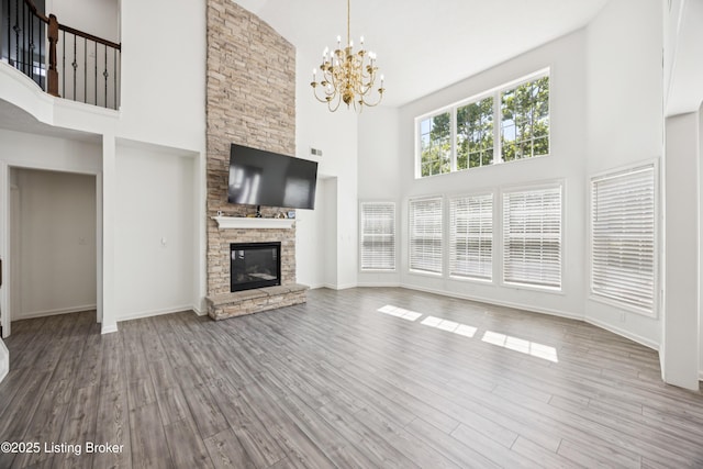 14433 Halden Ridge Way, Louisville, KY 40245 - unfurnished living room with a towering ceiling, wood finished floors, a stone fireplace, and a chandelier