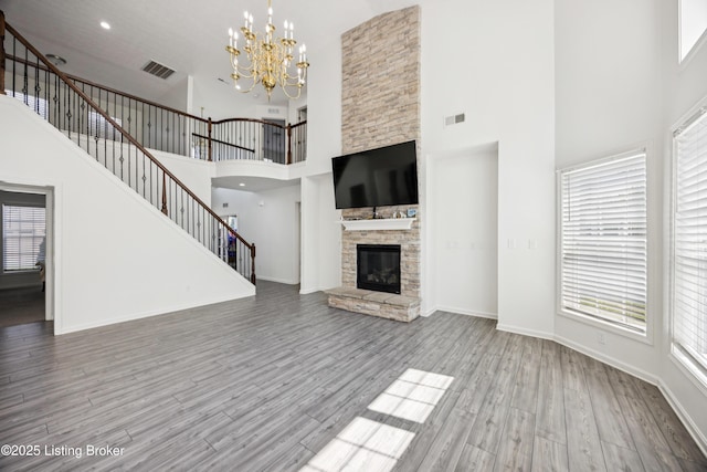 14433 Halden Ridge Way, Louisville, KY 40245 - unfurnished living room featuring a high ceiling, wood finished floors, a chandelier, stairway, and a fireplace