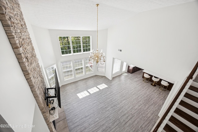 14433 Halden Ridge Way, Louisville, KY 40245 - unfurnished living room featuring a chandelier, high vaulted ceiling, wood finished floors, and stairs