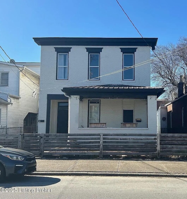 1214 Logan St, Louisville, KY 40204 - traditional-style house with a porch, brick siding, a fenced front yard, and a metal roof