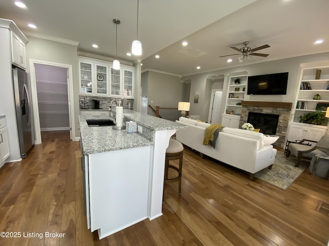 7508 Pavilion Park Rd, Louisville, KY 40214 - kitchen with a fireplace, stainless steel refrigerator with ice dispenser, crown molding, white cabinetry, and a kitchen bar