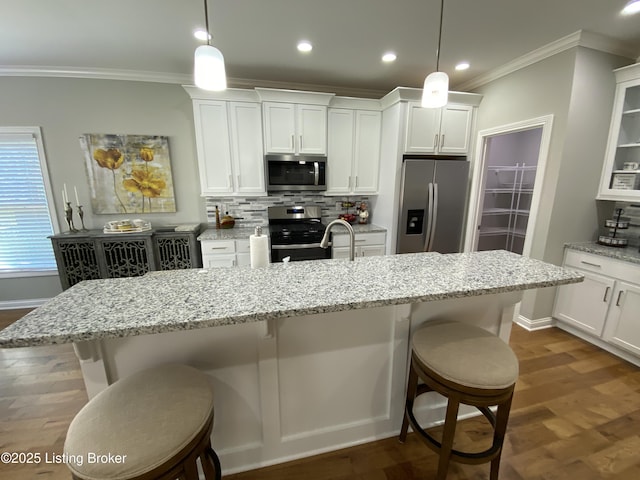 7508 Pavilion Park Rd, Louisville, KY 40214 - kitchen with stainless steel appliances, a breakfast bar, crown molding, backsplash, and white cabinetry