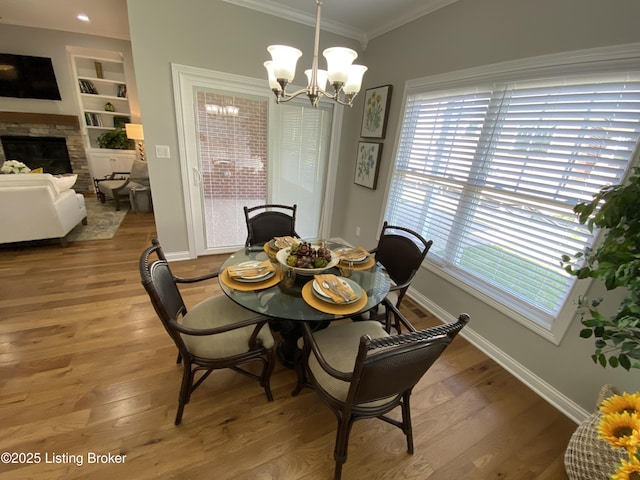 7508 Pavilion Park Rd, Louisville, KY 40214 - dining area with ornamental molding, a chandelier, a fireplace, light wood-style floors, and built in shelves