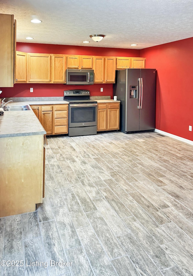 599 Ritchie Dr, Brandenburg, KY 40108 - kitchen featuring appliances with stainless steel finishes, light wood-style floors, light countertops, a textured ceiling, and recessed lighting