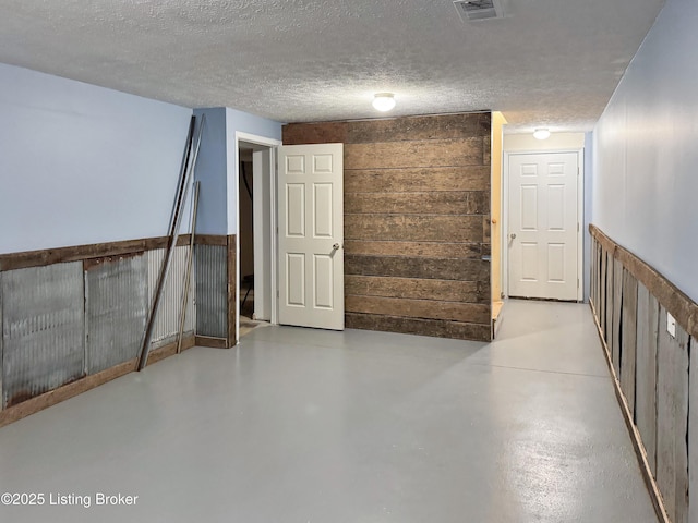 599 Ritchie Dr, Brandenburg, KY 40108 - below grade area featuring a textured ceiling, wood walls, and a wainscoted wall