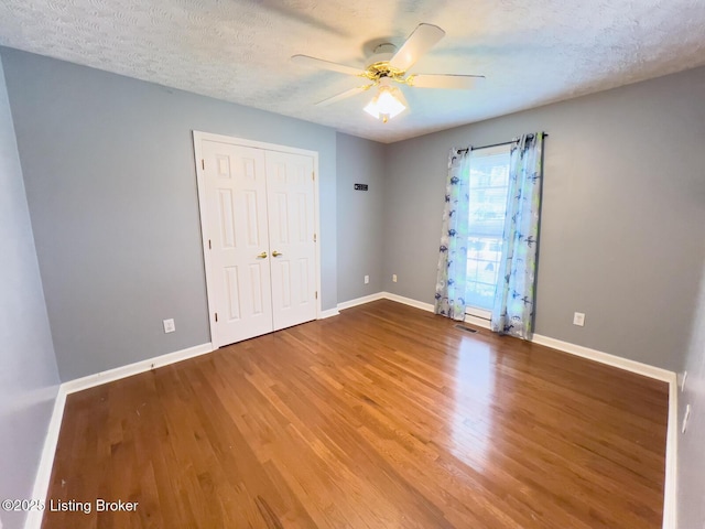 4212 Marseille Dr, Louisville, KY 40272 - unfurnished bedroom featuring wood finished floors, a textured ceiling, a closet, and a ceiling fan