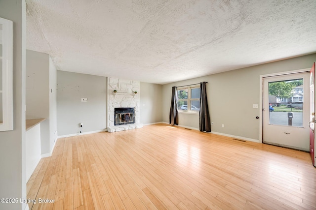 2700 Pioneer Ct, Radcliff, KY 40160 - unfurnished living room with a textured ceiling, a fireplace, and light wood finished floors