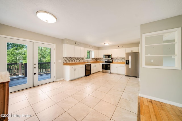 2700 Pioneer Ct, Radcliff, KY 40160 - kitchen with appliances with stainless steel finishes, light countertops, backsplash, french doors, and white cabinetry