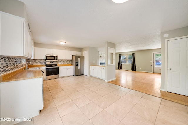 2700 Pioneer Ct, Radcliff, KY 40160 - kitchen with stainless steel appliances, backsplash, light tile patterned flooring, white cabinets, and light countertops