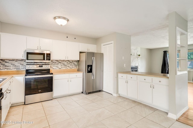 2700 Pioneer Ct, Radcliff, KY 40160 - kitchen featuring appliances with stainless steel finishes, tasteful backsplash, white cabinetry, light tile patterned floors, and a textured ceiling