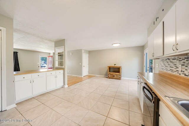 2700 Pioneer Ct, Radcliff, KY 40160 - kitchen with black dishwasher, decorative backsplash, white cabinetry, light tile patterned flooring, and light countertops