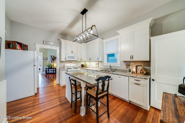 1021 Mulberry St, Louisville, KY 40217 - kitchen featuring white appliances, dark wood-style flooring, white cabinetry, light stone countertops, and decorative light fixtures