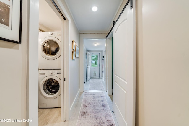 1021 Mulberry St, Louisville, KY 40217 - laundry room with stacked washer / drying machine, light wood finished floors, and a barn door