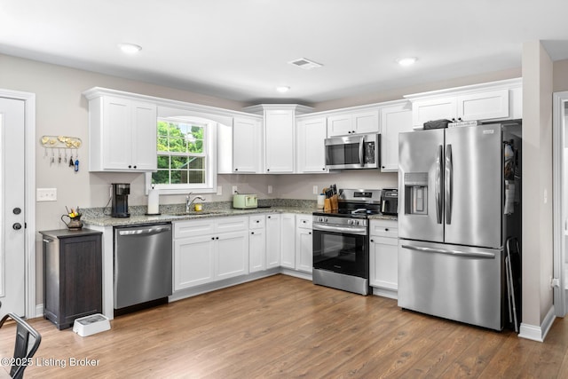 112 Shallow Springs Ct, Bardstown, KY 40004 - kitchen featuring stainless steel appliances, white cabinetry, wood finished floors, light stone countertops, and recessed lighting