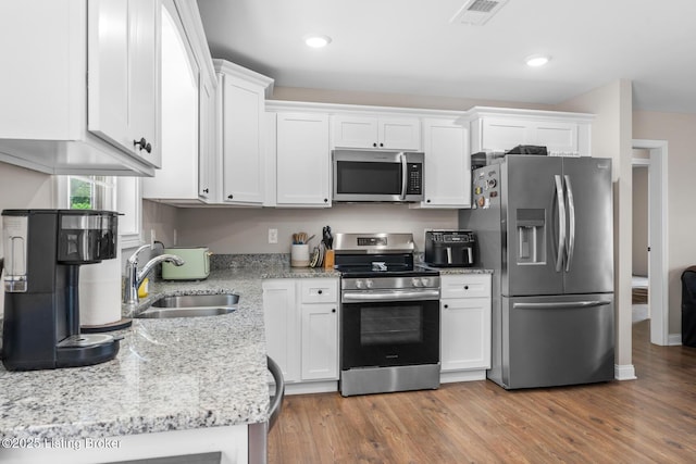 112 Shallow Springs Ct, Bardstown, KY 40004 - kitchen featuring appliances with stainless steel finishes, white cabinets, wood finished floors, light stone counters, and recessed lighting