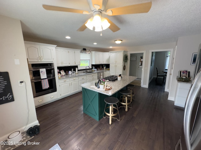 173 Megan Way, Falls Of Rough, KY 40119 - kitchen featuring white cabinetry, a kitchen breakfast bar, a ceiling fan, a center island, and recessed lighting