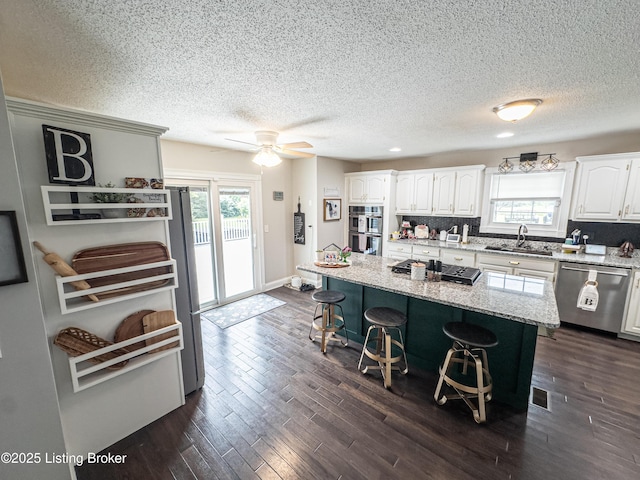 173 Megan Way, Falls Of Rough, KY 40119 - kitchen with stainless steel appliances, a kitchen breakfast bar, white cabinetry, dark wood finished floors, and a textured ceiling