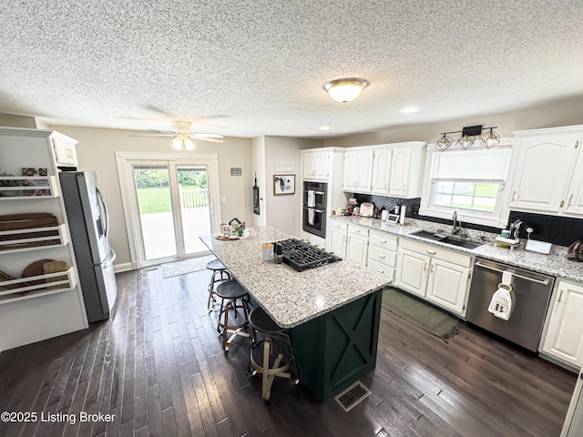 173 Megan Way, Falls Of Rough, KY 40119 - kitchen with stainless steel appliances, plenty of natural light, a kitchen breakfast bar, white cabinetry, and a textured ceiling