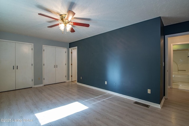 41 Raspberry Ct, Brandenburg, KY 40108 - unfurnished bedroom featuring wood finished floors, multiple closets, and a ceiling fan