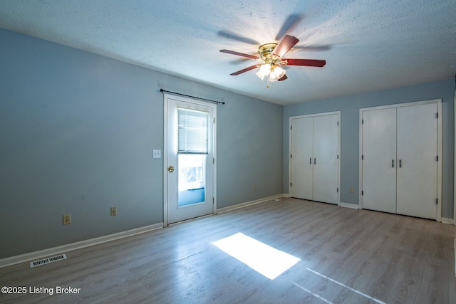 41 Raspberry Ct, Brandenburg, KY 40108 - unfurnished bedroom with wood finished floors, two closets, a textured ceiling, and a ceiling fan