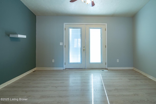 41 Raspberry Ct, Brandenburg, KY 40108 - unfurnished room featuring french doors, plenty of natural light, a ceiling fan, light wood-style flooring, and a textured ceiling
