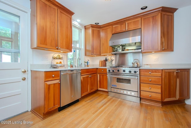 1211 Everett Ave, Louisville, KY 40204 - kitchen with stainless steel appliances, exhaust hood, light wood-style flooring, light countertops, and recessed lighting